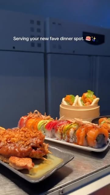 Rainbow roll, krokante sushirolls en bao buns op schalen in de keuken